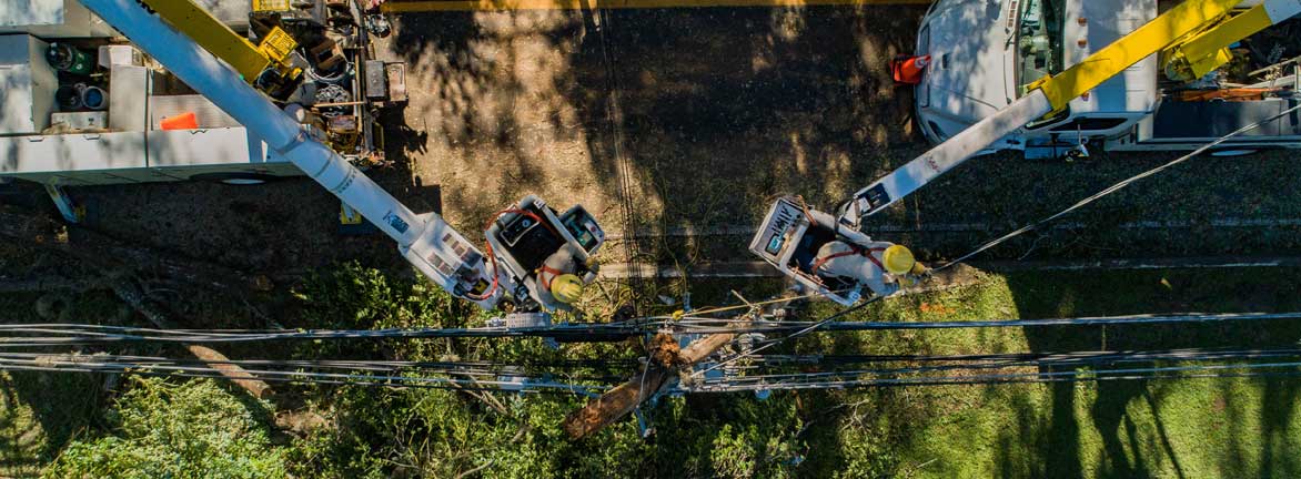 Utility crews working to fix a broken pole